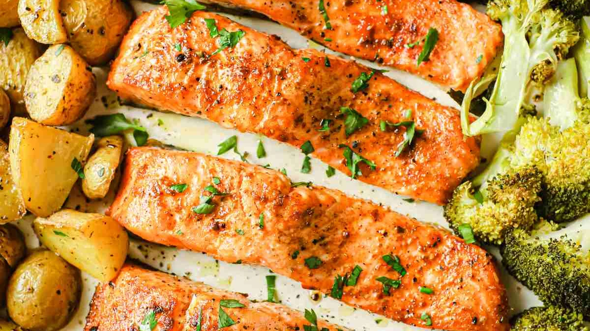 Laxfiléer och små potatisar med citron på en bakplåt